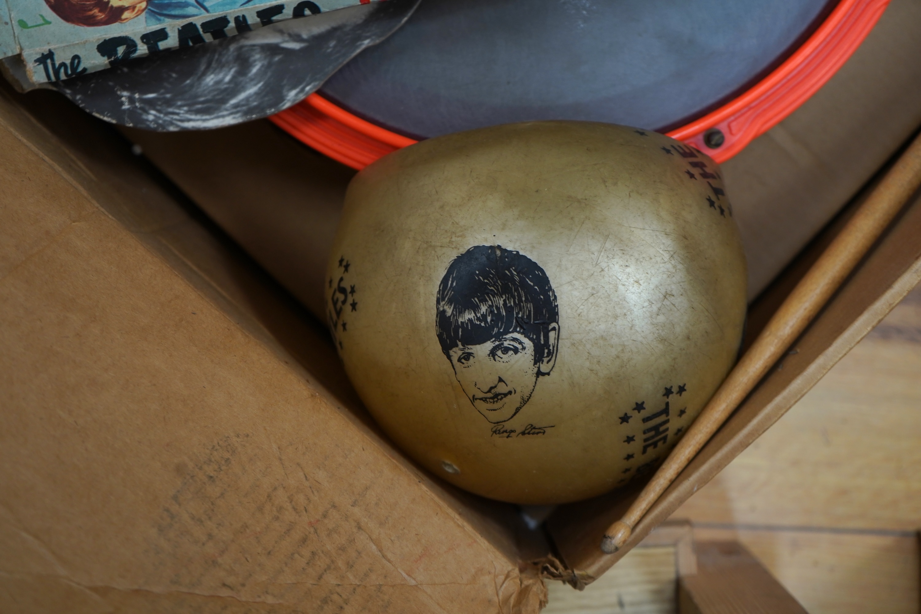 A 1960's Beatles child's plastic drum set in the original card box comprising of a snare drum on a stand, a card cut out bust of Ringo Starr, two 1960s Beatles jigsaws (unchecked) and a Beatles inflatable ball
